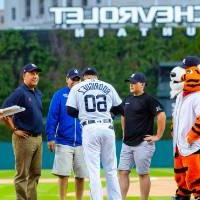 Group of 4 with Detroit Tigers player on Comerica Park field
